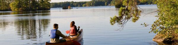 A couple canoeing on Pawtuckaway Lake in New Hampshire's Pawtuckaway State Park.