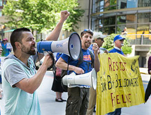 Photo: Man at climate rally speaks into megaphone