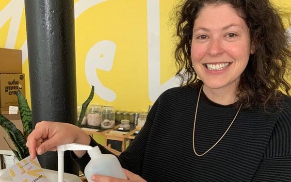 Photo of Sarah Levy refilling a shampoo bottle in Cleenland