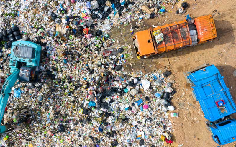 landfill with garbage trucks