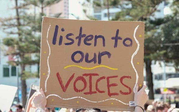 Protest sign reads: Listen to our voices