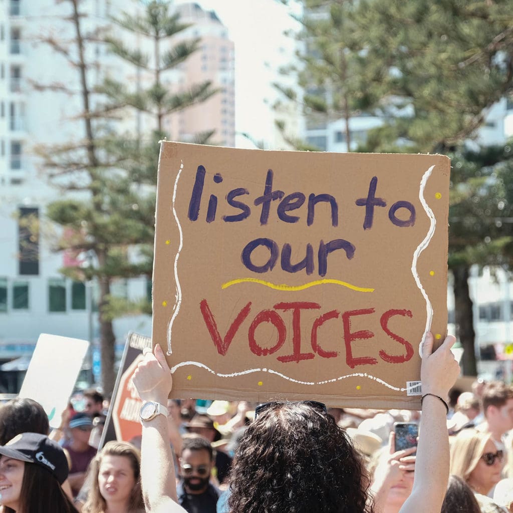 Protest sign that says "Listen to our voices"