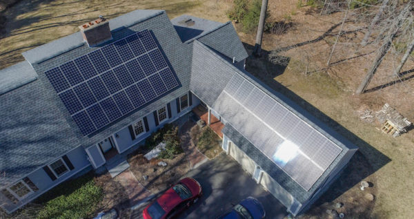 Overhead shot of a house with solar panels and electric cars