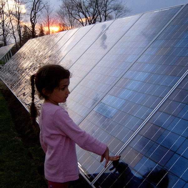 Girl standing next to solar panel
