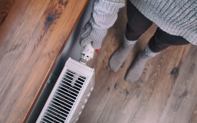 New England electricity prices are spiking this winter – and the reason why is our over dependence on fossil fuels. Image: a person wearing mittens turns on a radiator.