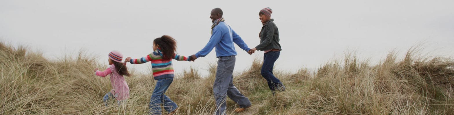 family running through a field of grass