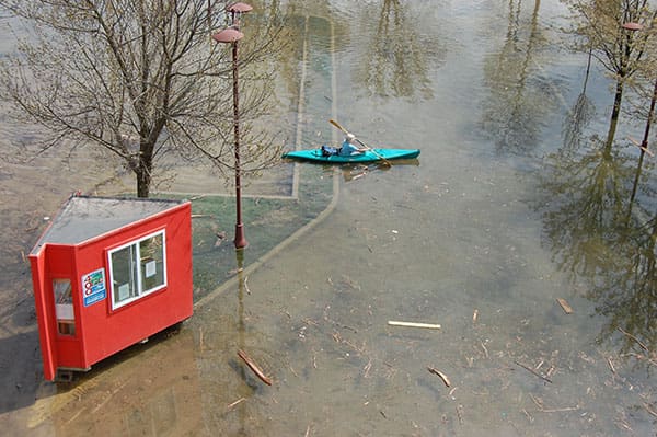 A kayaker on a flooded parking lot.