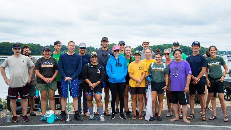 Timberland volunteers stand in front of the Great Bay estuary. In their hands, their hold paddling equipment and trash pickers they would use in the cleanup day. Photo: Adilson Gonzalez.