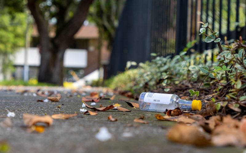 A bottle litters a sidewalk