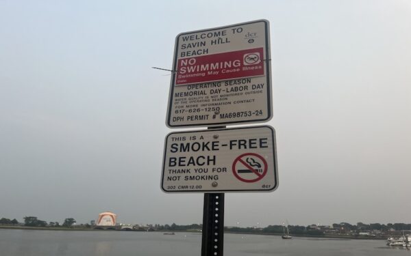 A sign warns swimmers to stay out of the water on Dorchester's Savin Hill Beach because of bacteria contamination
