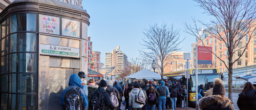 MBTA closure of Green Line Extension. Riders crowded outside to get on a shuttle bus.