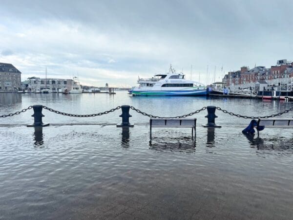 Sea waters flood a pedestrian walkway at Boston's waterfront.