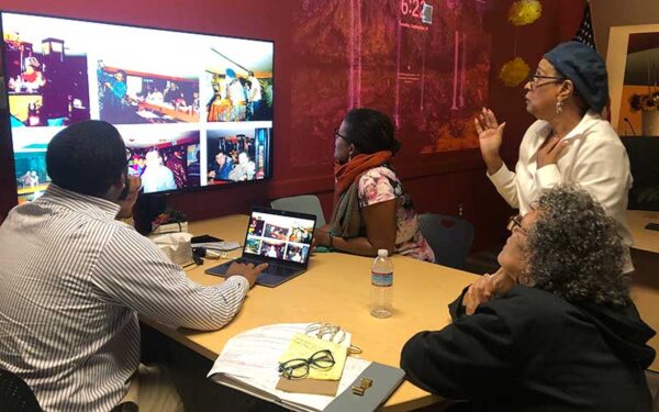 Members of the HNS team sit around a table reviewing photos for the Bomb Shelter book