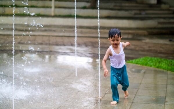 A child plays in fountain to beat summer humidity