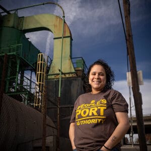 Monica Huertas of the People’s Port Authority in South Providence, Rhode Island, standing by industrial facilities at the Port of Providence.