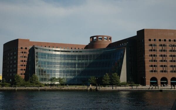 Exterior photograph of John J. Moakley United States Courthouse, a brick building with floor-to-ceiling glass windows facing Boston Harbor.