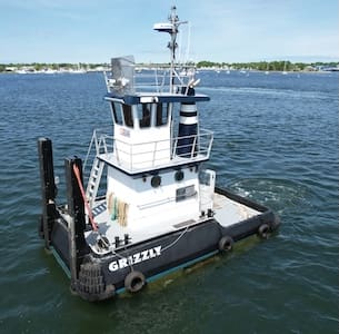 A small tugboat named Grizzly sits on the water.